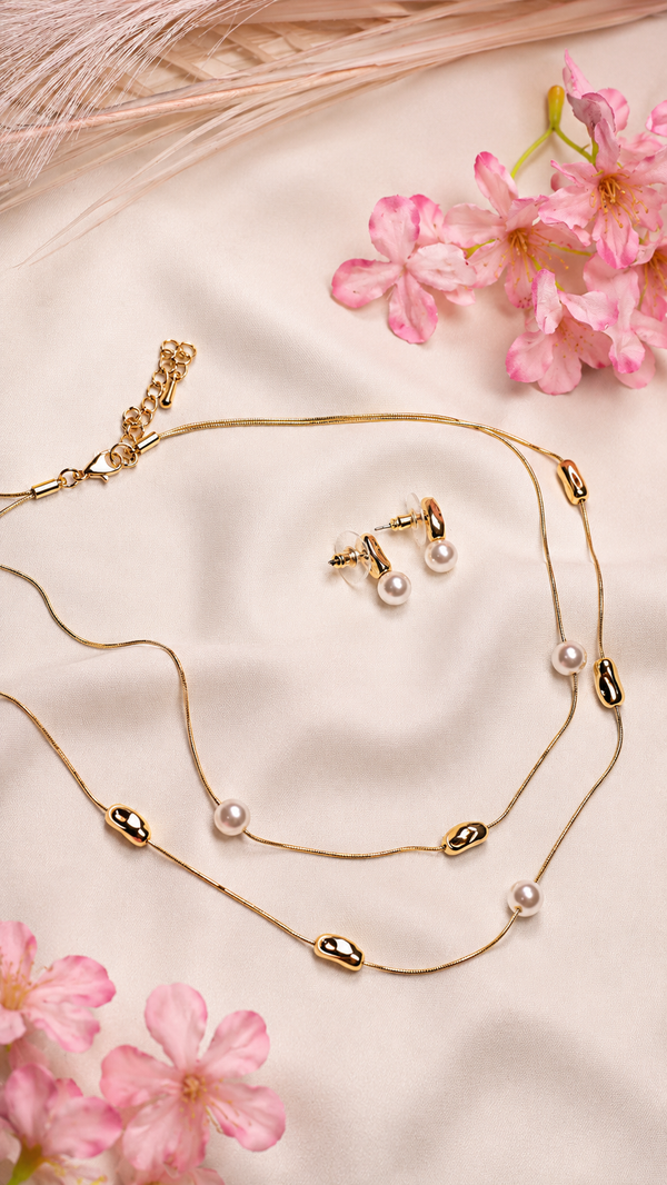 A Gold Necklace With Small White Pearls